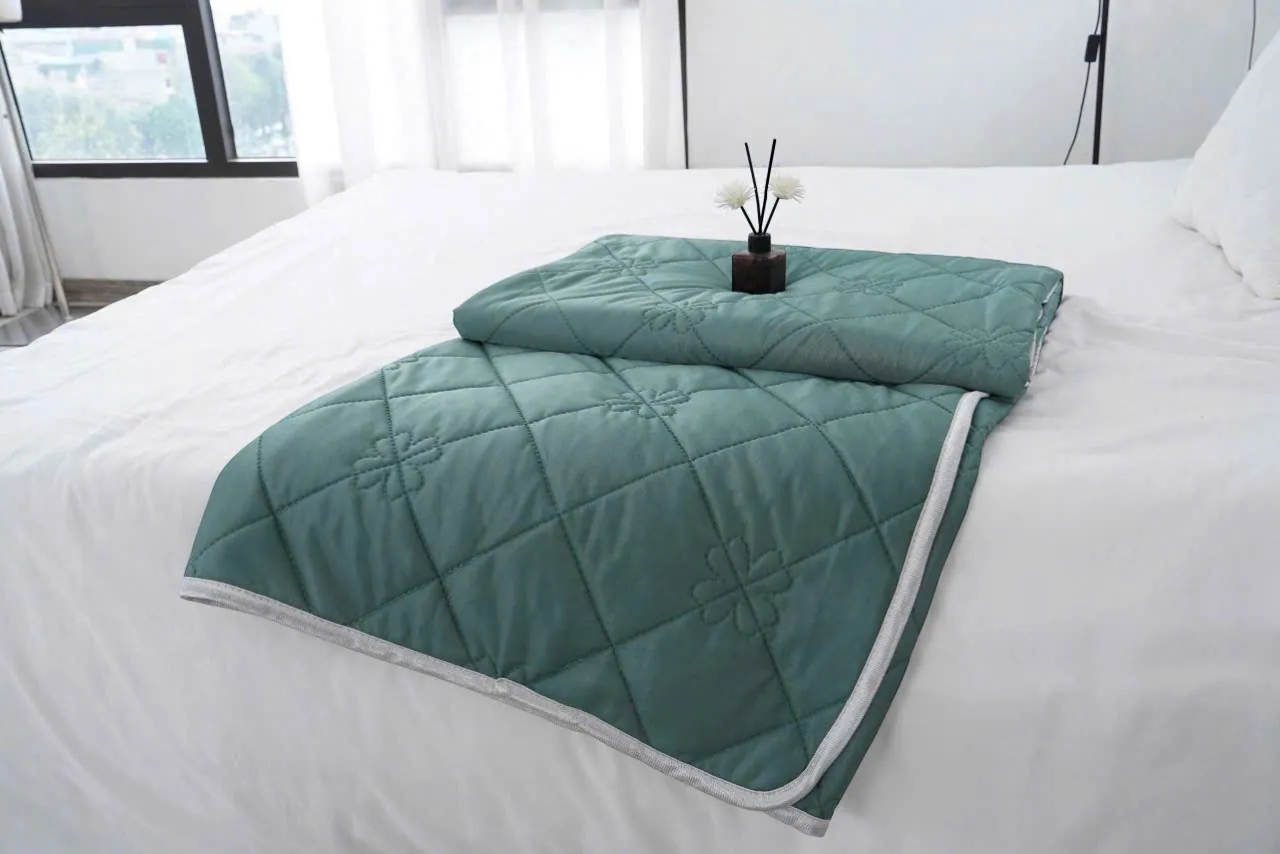 Ngôi nhà Chích Bông green ice silk microfiber quilt with floral embroidery and diamond quilting.